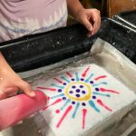 Gallery 1 - child decorating handmade paper with colored pulp