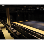 Gallery 5 - Theatre with black marley flooring installed over the wood floor. First few rows of theatre seating.