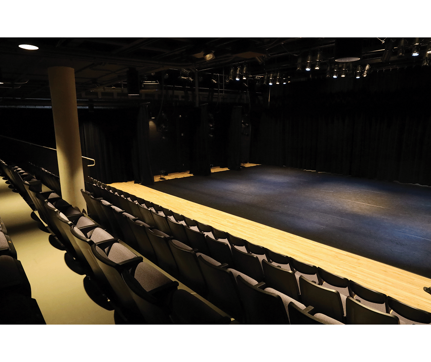 Gallery 5 - Theatre with black marley flooring installed over the wood floor. First few rows of theatre seating.
