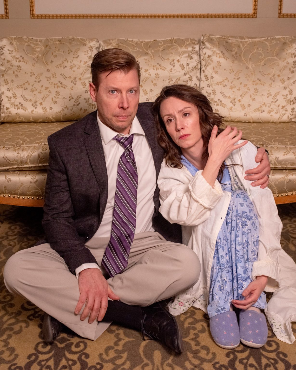 Gallery 2 - Worried couple seated on the floor leaning back on sofa