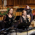 Gallery 5 - Handbell choir smiling while ringing bells