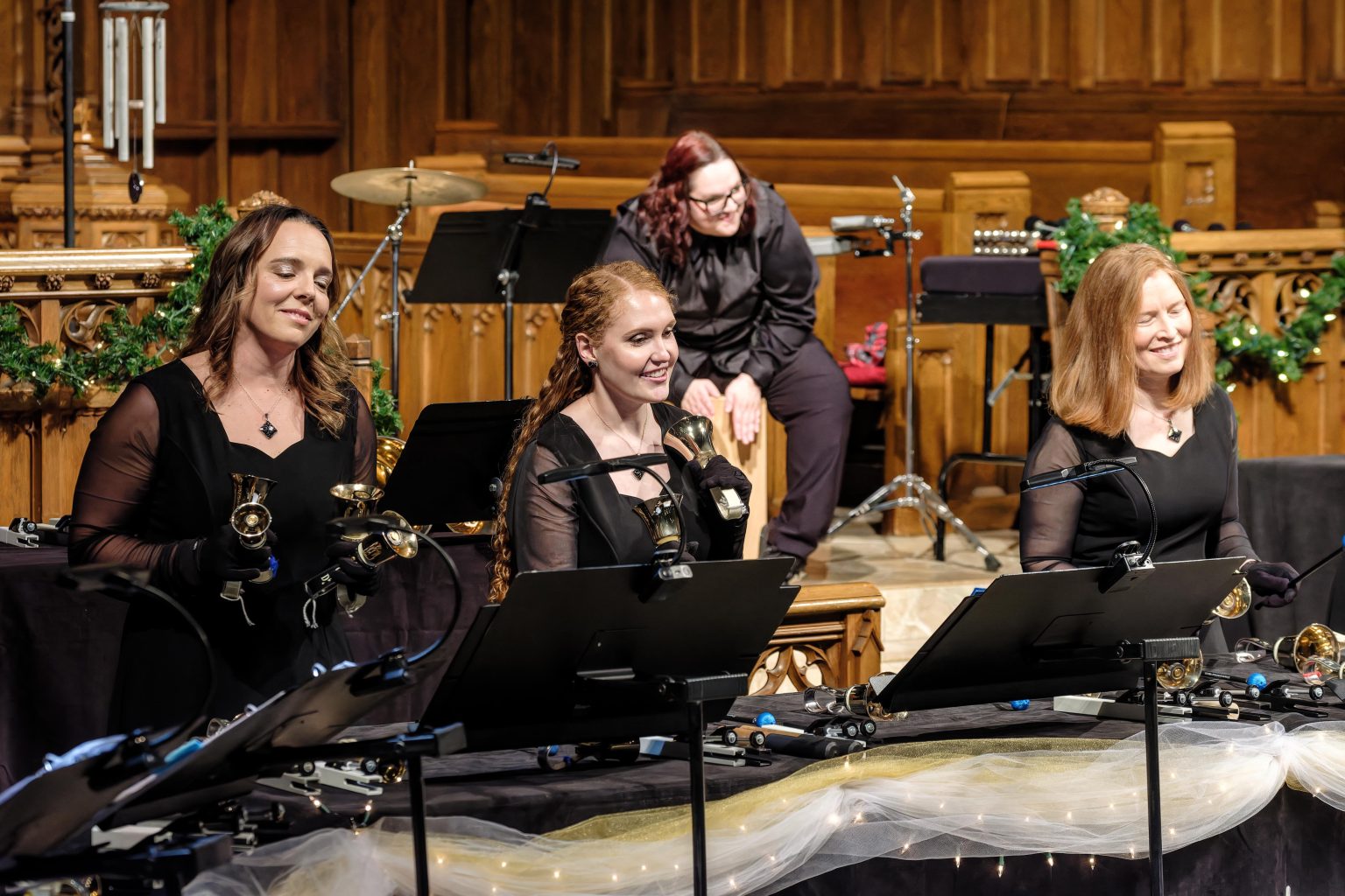 Gallery 5 - Handbell choir smiling while ringing bells